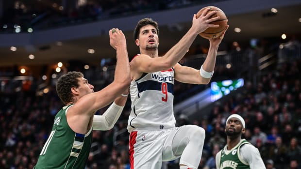 Washington Wizards forward Deni Avdija (9) takes a shot between Milwaukee Bucks center Brook Lopez (11) and forward Bobby Portis (9) at Fiserv Forum.